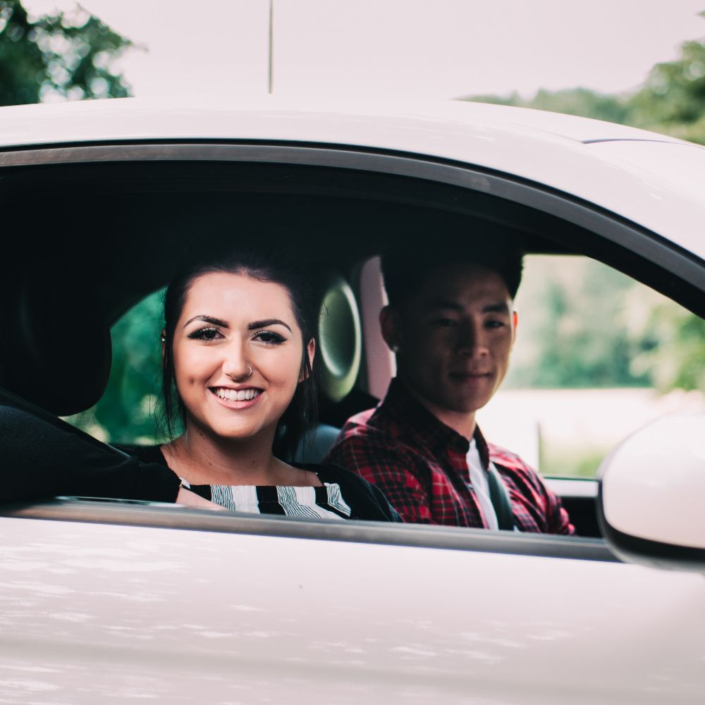 Young Couple sitting in a white Fiat 500